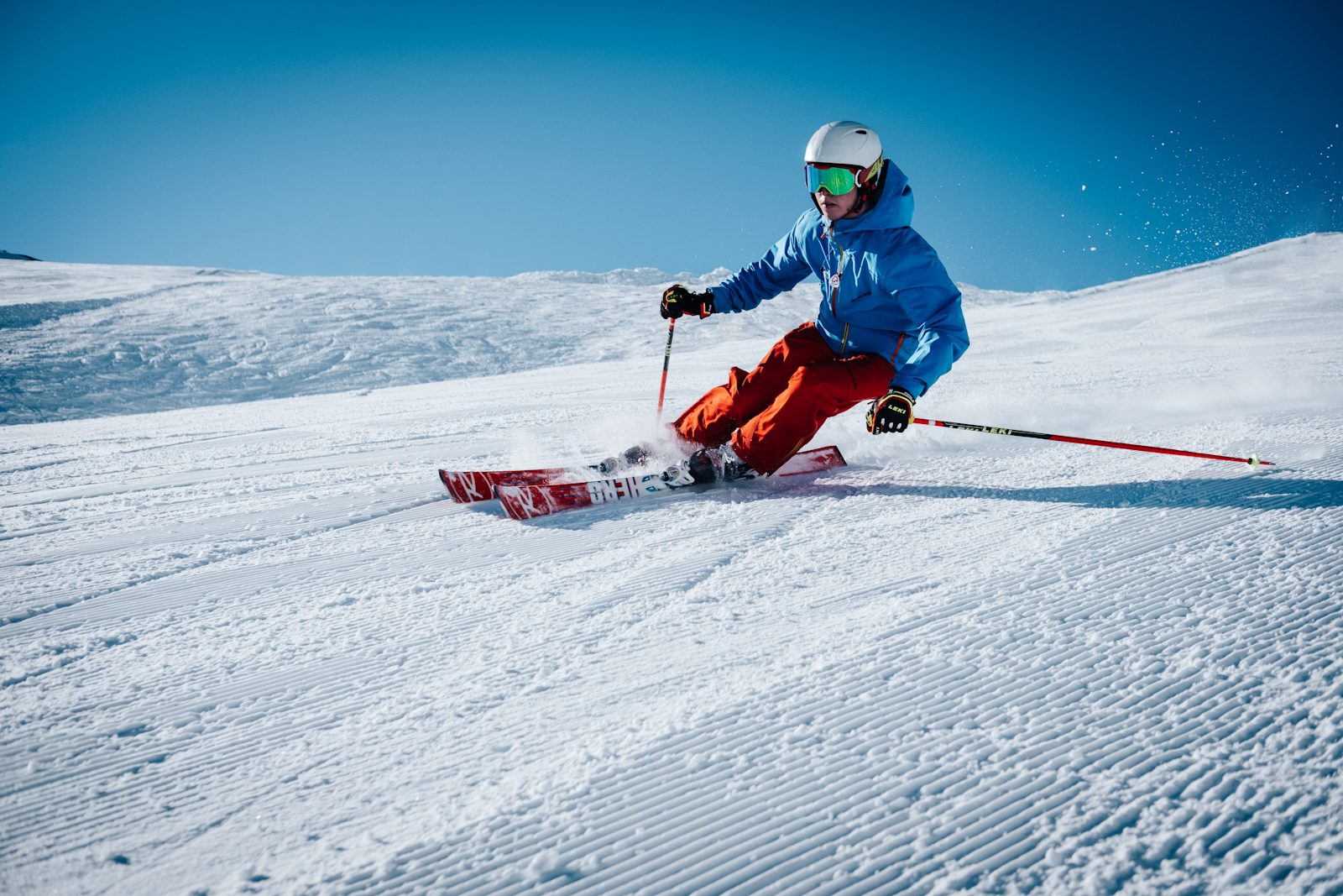 First Chair Ski Co. Skier carving on a groomed run.