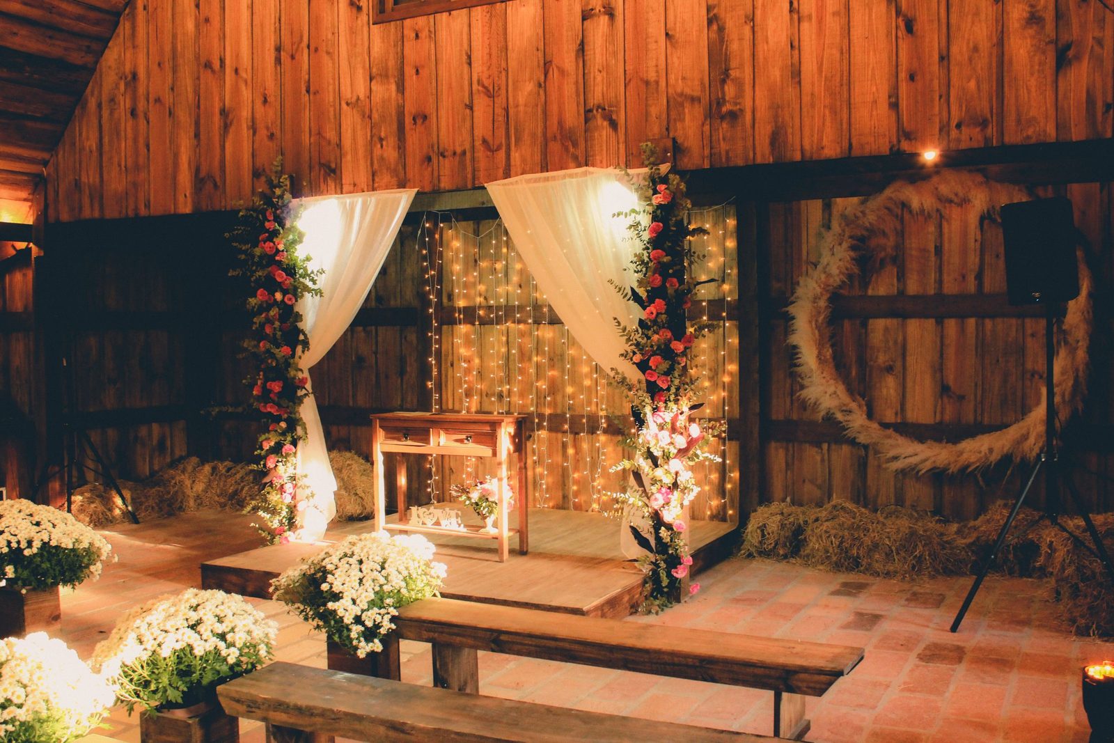 The Hay Loft. A barn aisle strung with lights and flowers.