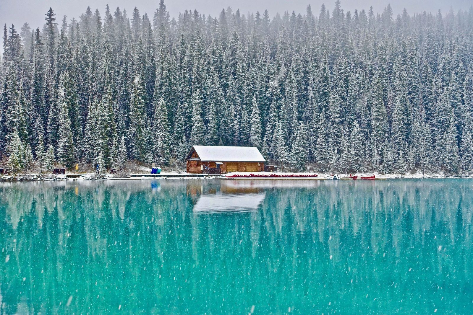 Open & Close Camp Care. A snowed-in cabin on a blue lake.