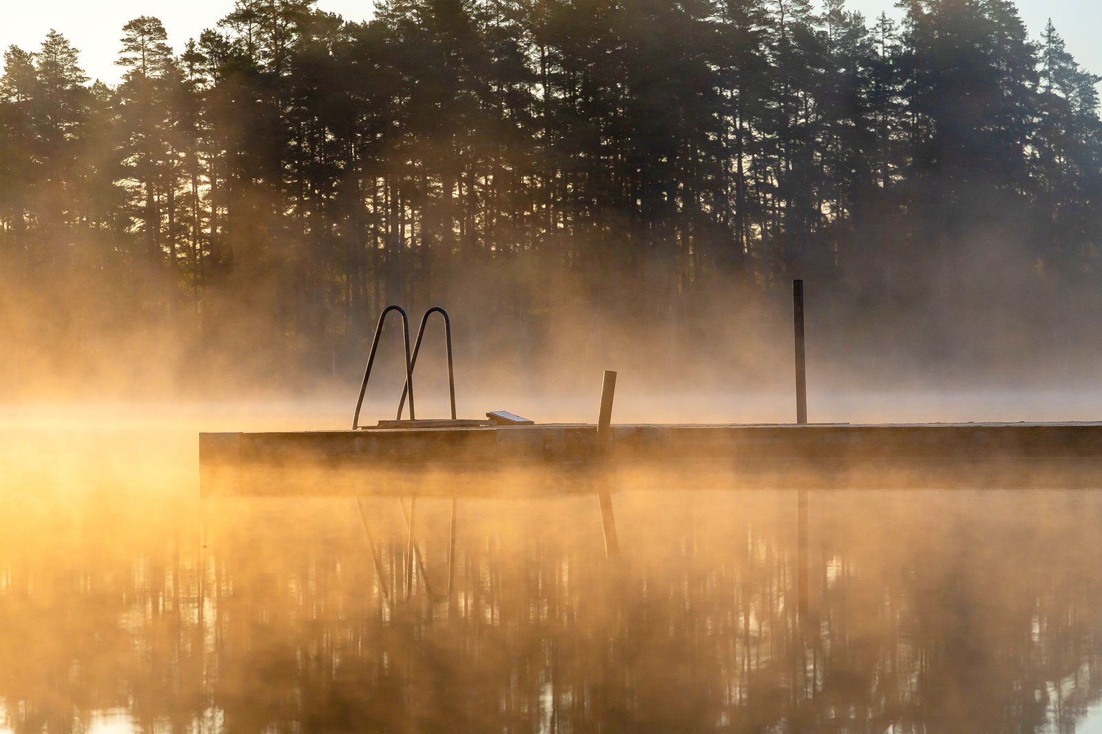 Swim Raft Lakefront Rentals. A swim raft off a dock at golden hour.