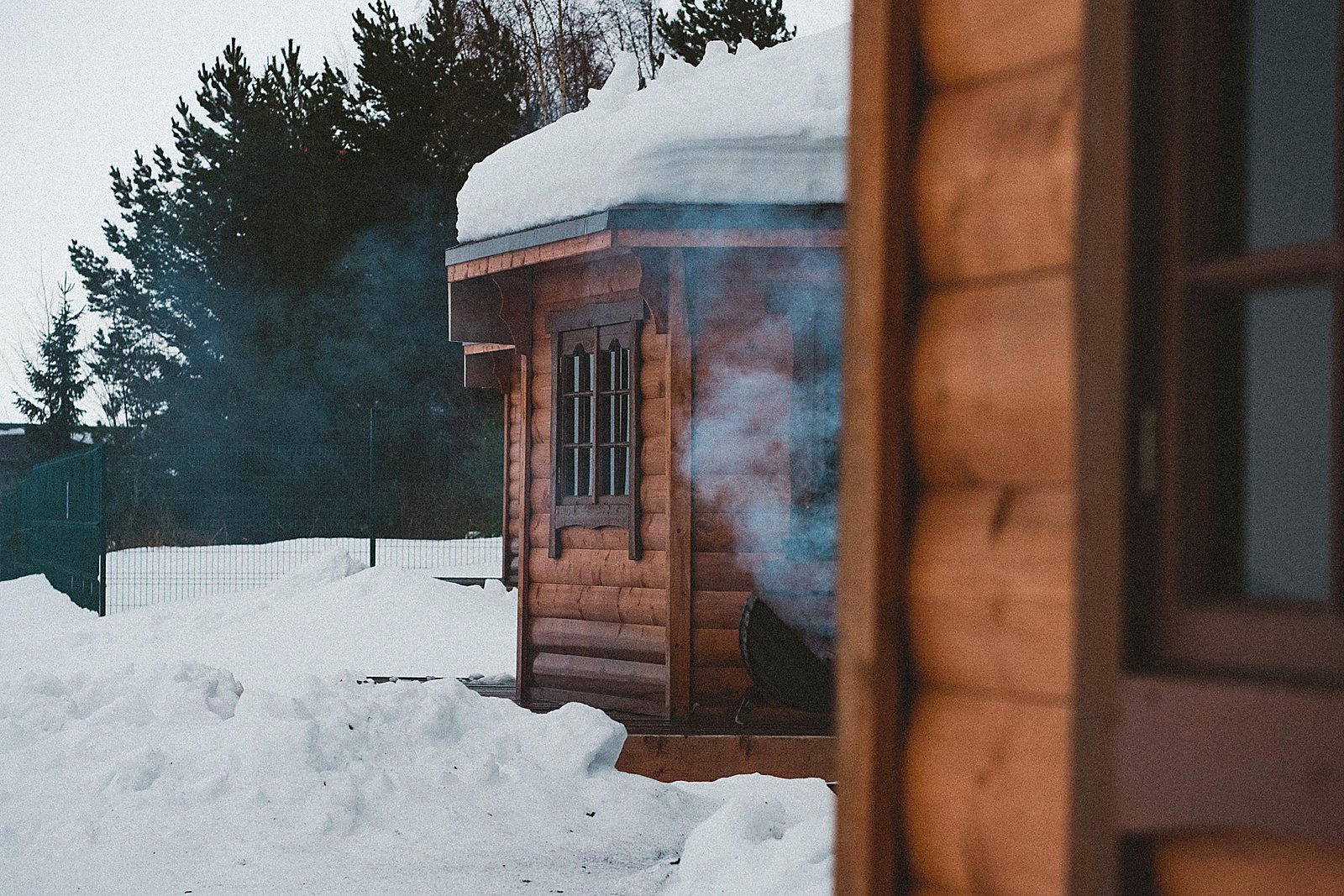 Log lodge nestled in deep snow with soft winter light.