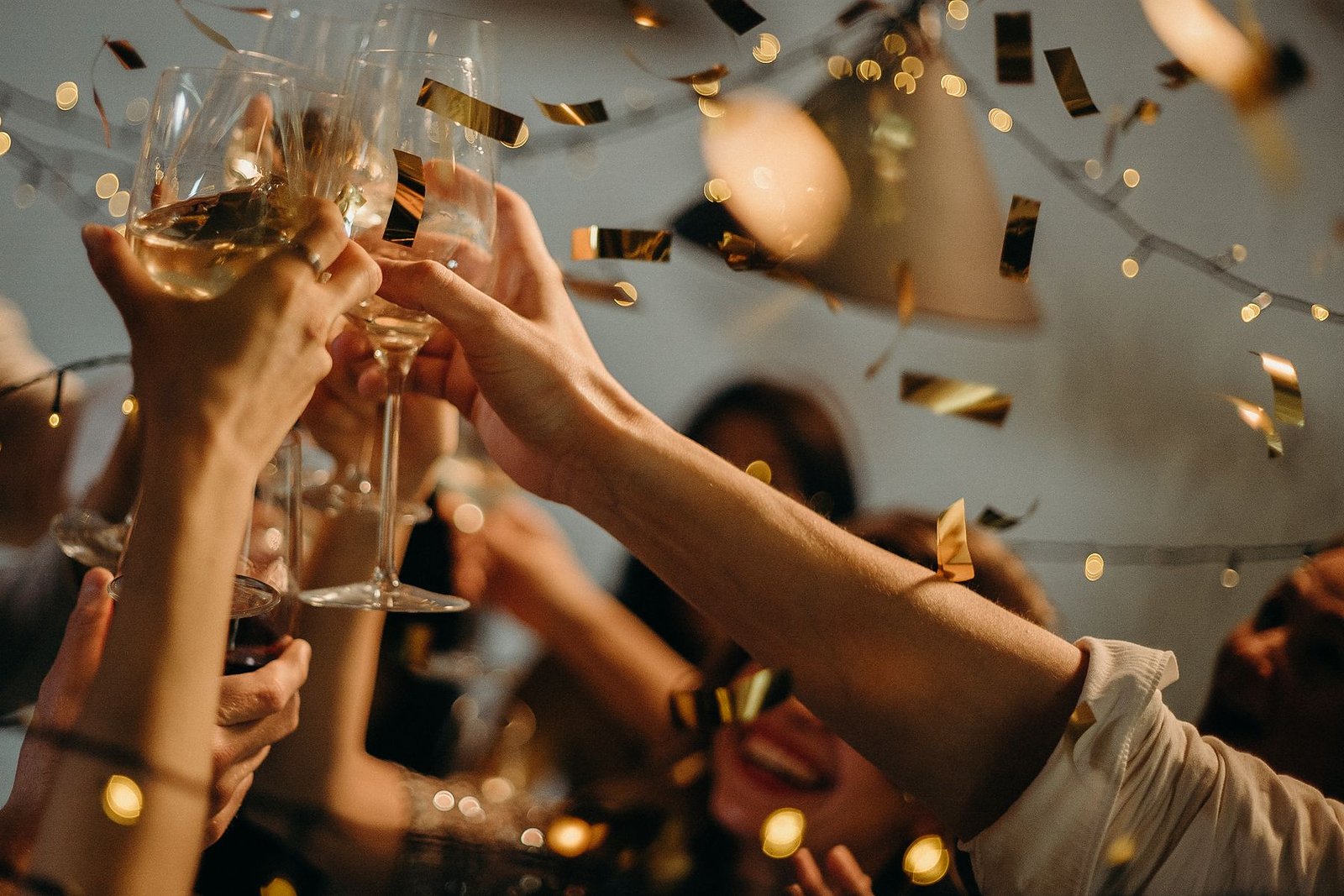 Guests raising glasses in a warm golden toast.