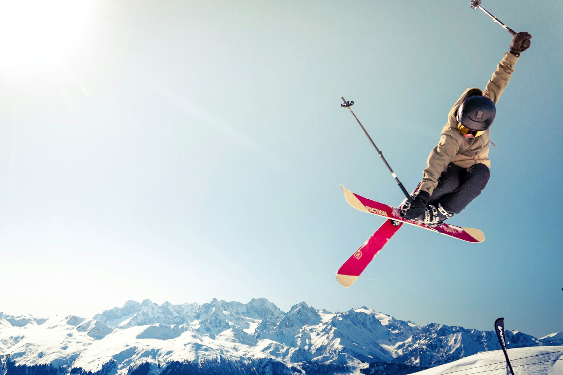 Powder Line Ski Co. Skier airborne over a groomed run.